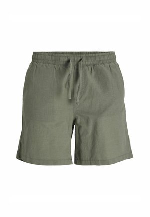 T-shirt crème à manches courtes avec texte imprimé, short vert, baskets beige clair avec accents, et chaussettes beiges. Coupe simple et décontractée.