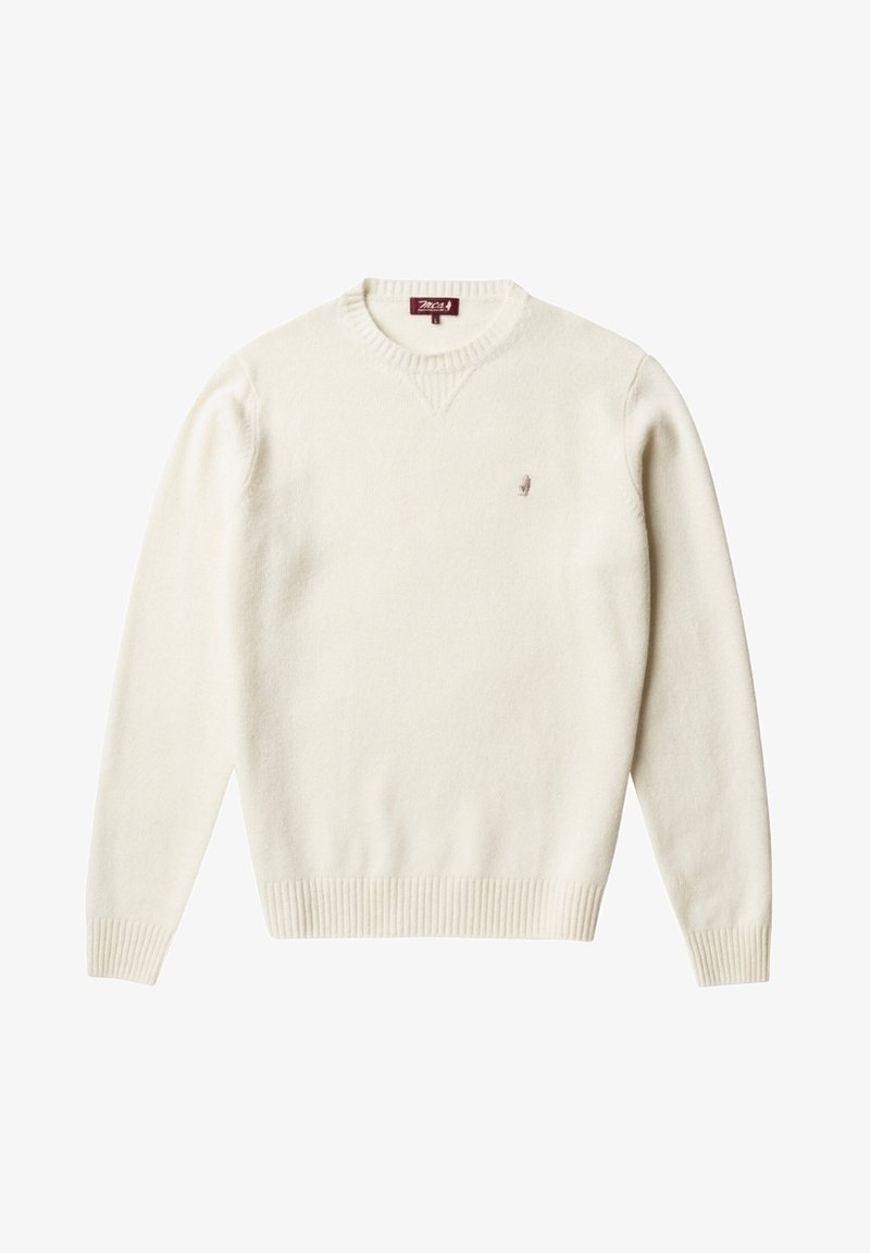 Pull à manches longues couleur crème avec poignets et ourlet côtelés, col rond, et petit logo brodé sur le côté gauche de la poitrine.