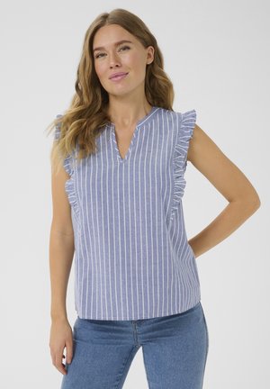 Blouse rayée bleu clair et blanche avec des manches à volants et un col en V, fabriquée en tissu doux. Portée avec un jean bleu ajusté.