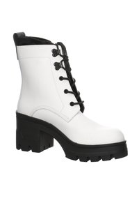 Botín blanco hasta el tobillo con cordones negros, punta redonda y un tacón grueso negro. Hecho de un material suave con una suela texturizada y un collar acentuado.