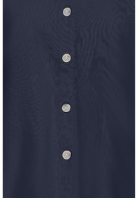 Tela azul marino con una fila vertical de cuatro botones redondos de color claro espaciados de manera uniforme en el centro.