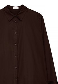 Brun langærmet skjorte med spids krave, frontlukning med knapper og subtil tekstur, der har kontrasterende syninger langs sømmene.