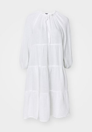 Biała sukienka do kolan z lekkiego materiału, z okrągłym dekoltem, bufiastymi rękawami oraz warstwowym krojem z poziomymi szwami.