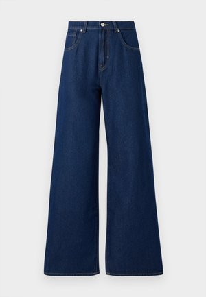 Jean en denim à jambes larges dans une teinte bleu foncé. Doté d'un design classique à cinq poches, de boutons de fermeture et de coutures contrastantes. Texture lisse.