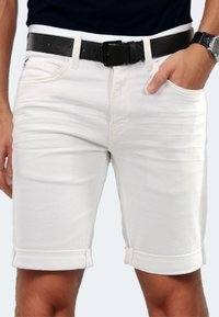 White denim shorts with rolled cuffs, featuring side pockets and a black leather belt. Smooth texture and a fitted design.