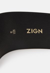 Cintura in pelle nera con logo "ZIGN" dorato impresso, taglie 80 M / 32, con texture del bordo finemente cucita.