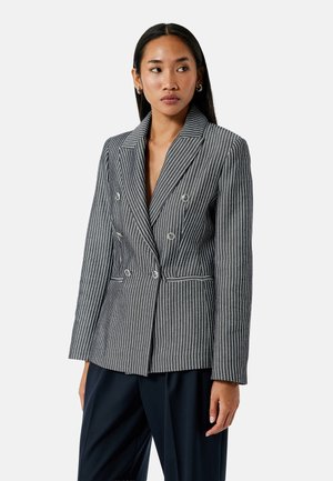 Gestreepte dubbele blazer in zwart en wit. Kenmerkt zich door een notch-kraag, knoopdetails en voorzakken met contrasterende piping.
