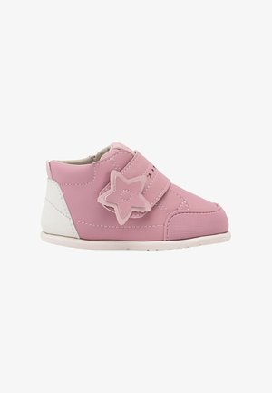 Zapato rosa para niño pequeño con talón blanco, suela suave y cierre de velcro en forma de estrella sobre fondo blanco.