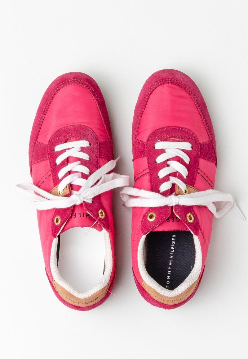 Paire de baskets rouges et roses avec des lacets blancs et des accents marron au talon, vue de dessus sur fond blanc.