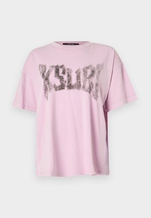 Lys rosa oversized T-skjorte med korte ermer og rund hals. Har et stort svart grafisk trykk av ordet "KSUBI" på forsiden.