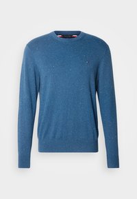Niebieski sweter z dzianiny, z okrągłym dekoltem i cętkowaną fakturą. Małe logo na lewej piersi. Długie rękawy.
