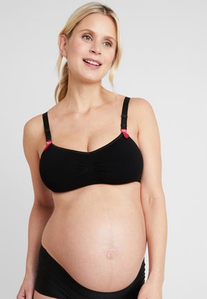 Black maternity bra with elastic fabric, gathered center detail, adjustable straps, and pink clips. Suitable for nursing.