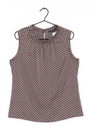 Blouse sans manches avec motif abstrait marron, blanc et rose, col rond avec petit détail œillet, suspendue sur un cintre noir.