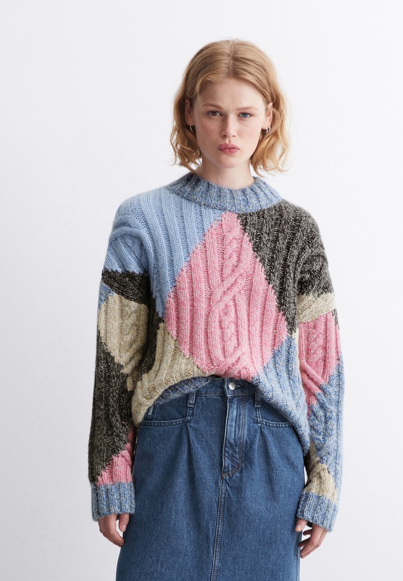 Mehrfarbiger gestrickter Pullover mit einem Diamantmuster, das blaue, rosa, schwarze und beige Abschnitte aufweist; strukturiert mit Kabelstrick-Details.