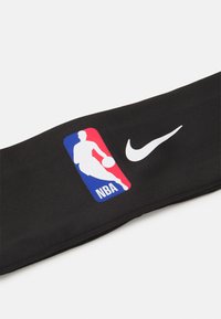 Sort sportshovedbånd med et farverigt NBA-logo på den ene side og et hvidt Nike Swoosh-logo. Fremstillet af elastisk, struktureret polyesterstof.