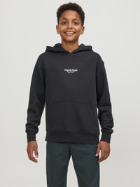 Hoodie noir avec une poche kangourou à l'avant, présentant un texte blanc, des poignets et un ourlet côtelés. Porté avec un pantalon vert foncé.