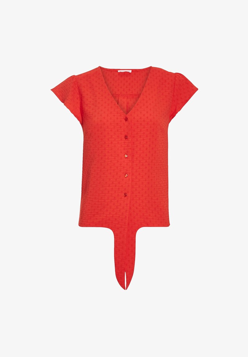 Blouse rouge à manches courtes avec col en V, boutons sur le devant, motif texturé subtil et détail noué à l'ourlet devant.