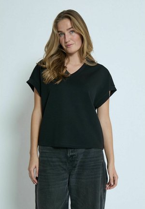 Black short-sleeve top with a V-neck design and relaxed fit, made from soft fabric. Paired with dark gray loose-fitting pants.
