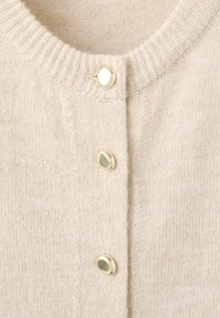 Cardigan de punto de color beige claro con un cuello acanalado, cuatro cierres de botones dorados y una textura suave. Ideal para combinar con diversos atuendos.
