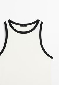 Sleeveless white tank top with black contrast trim around the neckline and armholes, made from smooth cotton fabric.