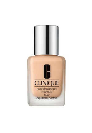 CLINIQUE Maquillaje Superbalanced en un frasco de vidrio transparente, presenta un líquido beige mate con una tapa plateada y un logotipo negro llamativo.