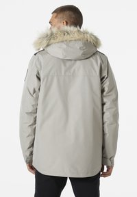 Grijze waterdichte parka met een bontgevoerde capuchon, lange mouwen en een ontspannen pasvorm. Kenmerken zijn een naadloze rug en zijzakken.
