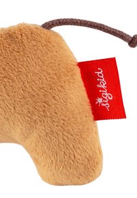 Soft, plush toy in light brown with a textured surface. Features a small red tag with white text, attached by a brown string loop.