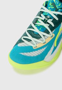 Turquoise athletic shoe with a textured fabric upper and neon yellow outsole. Features white accents and patterned lining with light blue laces.