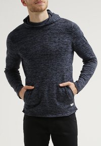 Marinblå långärmad hoodie med ett texturerat mönster, kängurufickor och hög hals; mjukt och stretchigt material.