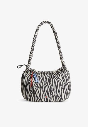 Sac à bandoulière avec rayures zèbre noires et blanches, sangle réglable, porte-clés "Tommy" rouge et bleu, et petit logo de la marque à l'avant.
