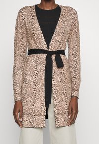 Beżowy kardigan w panterkę z długimi rękawami, dekoltem w serek oraz czarnym paskiem w talii. Miękki materiał, otwarty przód i prążkowana faktura.
