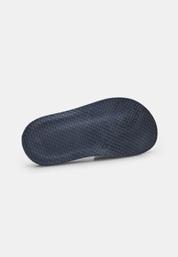 Talpa de pantof din cauciuc de culoare albastră, cu o suprafață texturată ce prezintă un model de fagure pentru aderență și durabilitate. Margini netede și formă rotunjită.