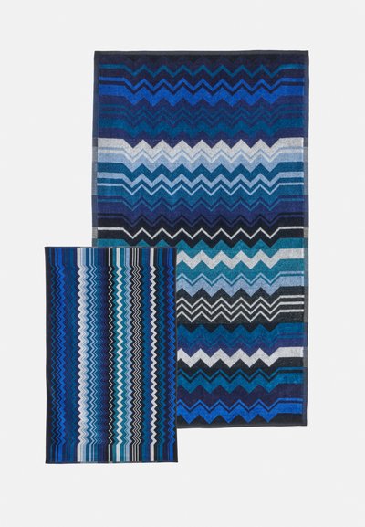 Deux serviettes bleues à motifs avec des dessins en zigzag et rayures dans différentes nuances de bleu, blanc et noir sur fond blanc.