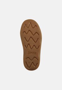 Suela de zapato de goma marrón con un patrón de tracción en zigzag y el logo "CAMPER" grabado. Bordes redondeados, superficie texturizada, diseñada para proporcionar agarre.