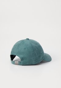 Teal kordfløyelsbaseballcaps med buet skjerm, justerbar stropp bak, og teksturert stoff, med seks ventilasjonshull.