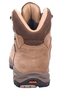 Brown suede hiking boot with a padded collar, robust sole, and black rubber accents. Features a zip closure and contrasting stitching details.