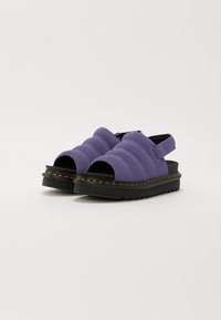 Lilla polstrede sandaler med åben tå, justerbar rem og sort gummisål med gule stikninger og tekstureret design.