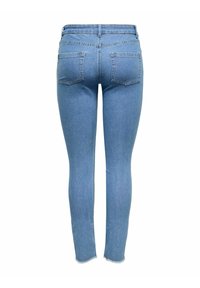 Jeans ajustados en denim azul claro, con una cintura alta, cinco bolsillos y un dobladillo sin terminar en el tobillo. Textura suave y diseño clásico.
