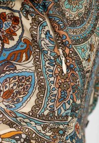 Patterned fabric featuring swirls and floral designs in blue, orange, and brown. Includes a white zipper at the side.
