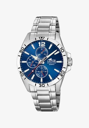 Zilveren stainless steel horloge met een blauwe wijzerplaat, voorzien van drie subwijzers, een datumindicator en grote cijfers. Kwartzuurwerkmechanisme.