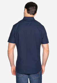 Kurzärmliges, navyfarbenes Hemd mit klassischem Kragen, glatter Textur und geradem Schnitt. Verfügt über eine Rückenpasse und dezente Nähte.
