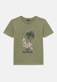 Olivegrünes Baumwoll-T-Shirt mit einem Grafikmotiv eines sich dehnenden Tigers und einer Palme, mit dem Text "SONNENBEGRÜSSUNG" in Schwarz.