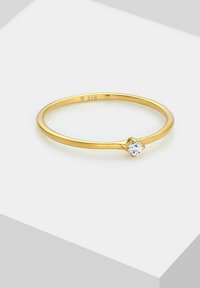 Gold-plated ring featuring a simple band design, adorned with a single clear gemstone set in a decorative clasp. Stamped 925 inside.