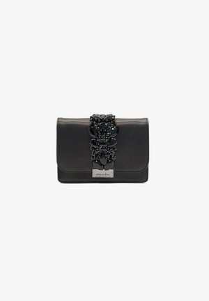 Clutch de cuero negro con un destacado detalle de joyería en el centro, con piedras negras de varias formas y un cierre metálico.