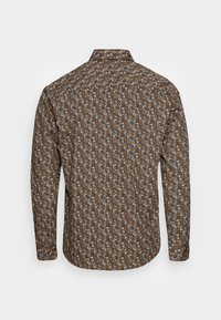 Koszula z długim rękawem na brązowym tle z kwiatowym wzorem w odcieniach pomarańczowego i białego. Tkanina wydaje się lekka i teksturowana.