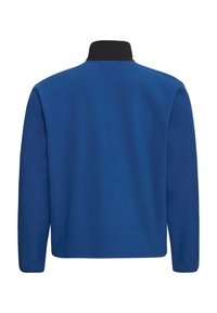 Veste en polaire bleu uni avec un col noir. Présente une coupe droite et des manches longues. Texture douce, design simple, sans logo visible.