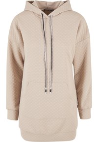 Sweat à capuche beige avec un motif matelassé, doté d'une poche avant et de cordons de serrage noirs. Manches longues avec des poignets côtelés.
