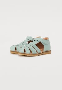 Lys blå lær sandaler med åpen tå-design, med kryssende stropper og borrelås-lukking. Tekstursåle i flat gummi.