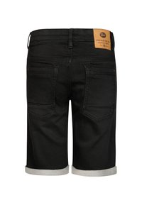 Pantalones cortos de mezclilla negra con dobladillo enrollado, con dos bolsillos traseros y un parche de marca de cuero color canela en la cintura. Textura suave.