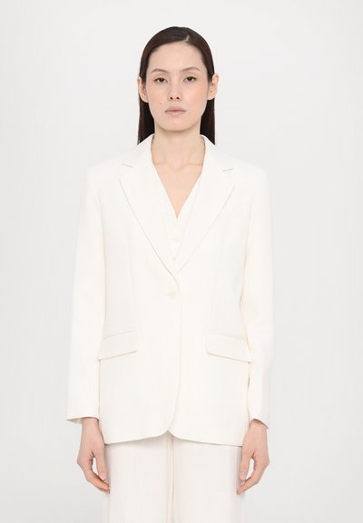 White pinstriped blazer with a structured design, single button closure, and two front pockets. Smooth fabric with a refined texture.